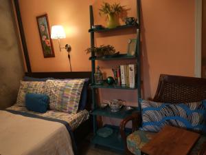 皇后区Cozy ground floor rooms at the heart of Jackson Heights的一间卧室配有一张床、一把椅子和一张桌子
