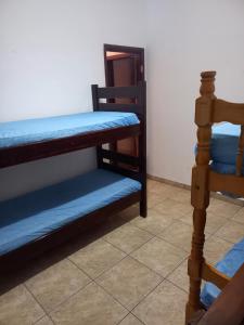 大普拉亚Casa em Praia Grande -SP的客房设有两张双层床和镜子