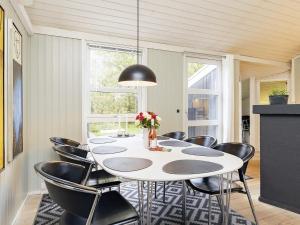 耶鲁普Holiday home Jerup LX的一间配备有白色桌子和黑色椅子的用餐室