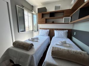 贝洛奥里藏特Apartamento em Belo Horizonte 2的小客房内的两张床和毛巾