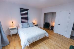 Ville-MarieAuberge Nouvelle-France的一间卧室配有白色床和蓝色枕头