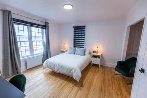 Ville-MarieAuberge Nouvelle-France的一间卧室配有一张床、两把椅子和两盏灯。