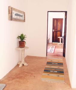 瓦塔穆Manasha Apartment 1的门旁桌子上摆放着盆栽植物的走廊