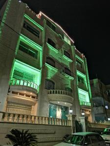 安曼Yaso Roof & Apartments的一座晚上有绿灯的建筑