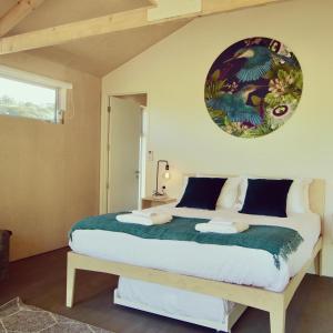 欧尼罗亚One O One Cabins, Waiheke Island的一间卧室配有一张带绿毯的大床