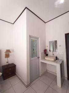 BangliEdu Hotel (Hotel Edukasi SMK PK)的白色的房间,设有门、桌子和镜子