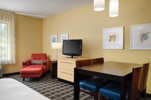安娜堡TownePlace Suites Ann Arbor的酒店客房配有书桌、电视和椅子。