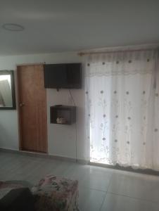 科科尔纳Casa 3 Cocorna的客厅配有窗帘和电视