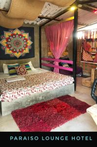 圣玛尔塔Paraiso Lounge的一间卧室配有一张红色地毯的大床