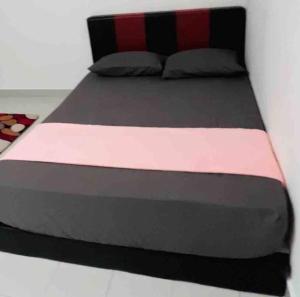 万津Afrinas Homestay @ Banting的一张大床,配有黑色粉红色的被子