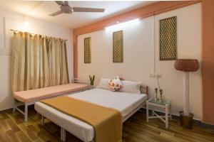 潘奇加尼Tabletop Villa Standard - 3的一间卧室配有两张床和吊扇