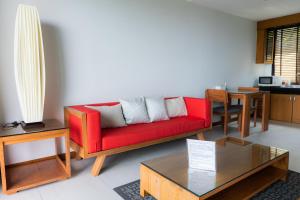 奥南海滩Aonang Suite Pool Villa的客厅配有红色的沙发和桌子