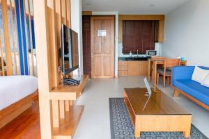 奥南海滩Aonang Suite Pool Villa的客厅配有蓝色的沙发和桌子