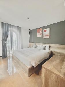 芽庄La Sera Suites Nha Trang的一间卧室设有一张大床和一个大窗户