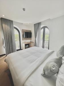 芽庄La Sera Suites Nha Trang的卧室设有一张带窗户的白色大床