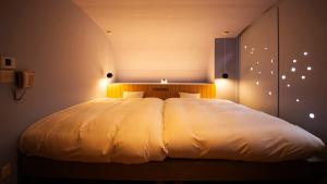 萩市リゾートホテル美萩的卧室里一张大白色的灯光床