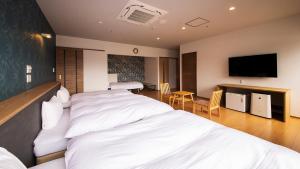 萩市リゾートホテル美萩的酒店客房设有两张床和一台平面电视。