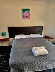 阿皮亚旅客柏银特酒店的一间卧室配有一张大床和两条毛巾