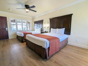 太平洋丛林Clarion Collection Wilkie's Inn Pacific Grove - Monterey的酒店客房配有两张床和吊扇。