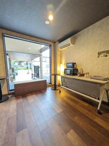 成田NARITA HOTEL KAKUREGA - Vacation STAY 69221v的客厅设有书桌和大窗户