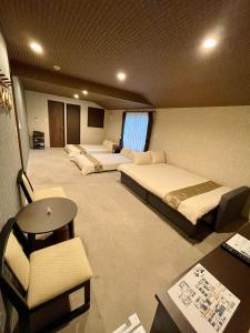 成田NARITA HOTEL KAKUREGA - Vacation STAY 72264v的酒店客房,设有两张床、一张桌子和椅子
