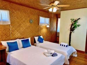 圣维森特Peak View Resort的配有蓝色枕头的客房内的两张床