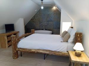 BoussièresGîtes de l'Orée du Bois的一间卧室配有一张木床和一个浴缸