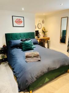 南安普敦Grade II boho home in the heart of Oxford St.的一间卧室配有一张大床和绿色床头板