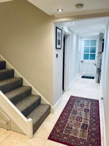 南安普敦Grade II boho home in the heart of Oxford St.的走廊上设有楼梯,地板上铺有地毯
