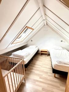 文代讷泽帕克海伦德克公寓的阁楼卧室设有两张床和楼梯。