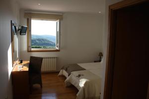 蒙塔莱格里艾呙齐奎那酒店的一间卧室配有一张床、一张书桌和一个窗户。