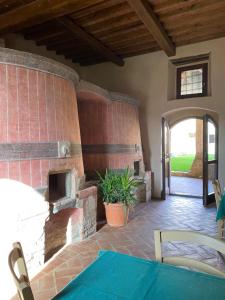 蒙特里久尼Ostello Contessa Ava dei Lambardi的房屋内带砖砌壁炉的庭院