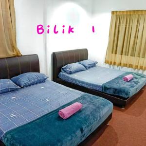 峇六拜Budget House Near Penang Airport Bayan Lepas Penang的配有两张床铺的蓝色和粉红色枕头
