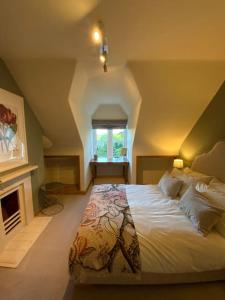法纳姆Ipsley Lodge Apartment Surrey Hills的一间卧室设有一张大床和一个壁炉