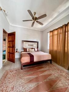 丹绒鲁Eagleye Langkawi的一间卧室配有一张床和吊扇