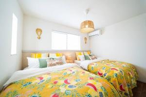 南城Sun flower的客房内的两张床和色彩缤纷的毯子