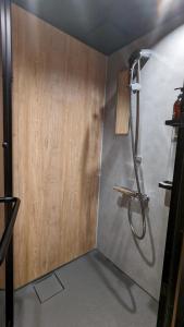 尾道市SIDOU 　INN的带淋浴的浴室(带木墙)