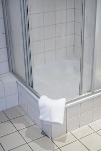 特里尔Hotel Constantin的带淋浴和白色毛巾的浴室
