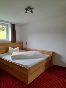 萨尔巴赫Hotel-Pension Wolfgang的一间卧室配有一张木床和窗户