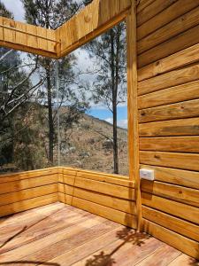 伊林加Jabali Mountain Cabin的木制小屋,甲板上设有大窗户