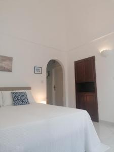 阿纳卡普里L'Archetto romantic suite in the center of Anacapri的白色的卧室配有白色的床和木制橱柜