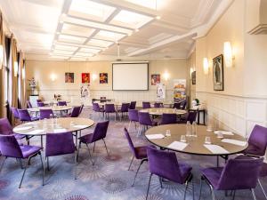 拉波勒拉波勒美居酒店的餐厅设有桌子、紫色椅子和黑板