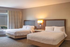 伯尼伯尔内汉普顿酒店及套房的酒店客房设有两张床和窗户。