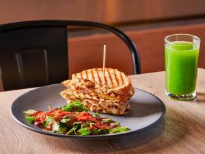 托雷翁Ibis Torreon的夹三明治、沙拉和绿饮料的盘子