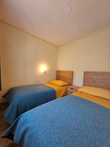 KojskoKamp Brda Camping and rooms的蓝色和黄色的客房内的两张床