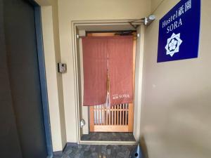 京都Higashi Shimbashi Building 3F Hostel Gion SORA - Vacation STAY 92728v的通往带窗户和标志的房间的门