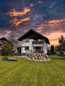 布莱德Vila Minka Bled - Perfect Family Vacation Home的庭院内的房子,背景是日落