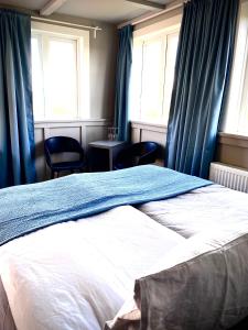 Bifrost豪森尼弗乡村酒店的一间卧室配有一张带蓝色窗帘的床和两把椅子