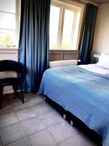 Bifrost豪森尼弗乡村酒店的卧室配有床、椅子和窗户。