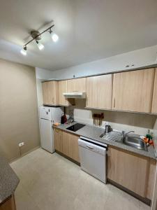 圭马尔港Apartamento La Marquesa Beach的厨房配有木制橱柜和白色冰箱。
